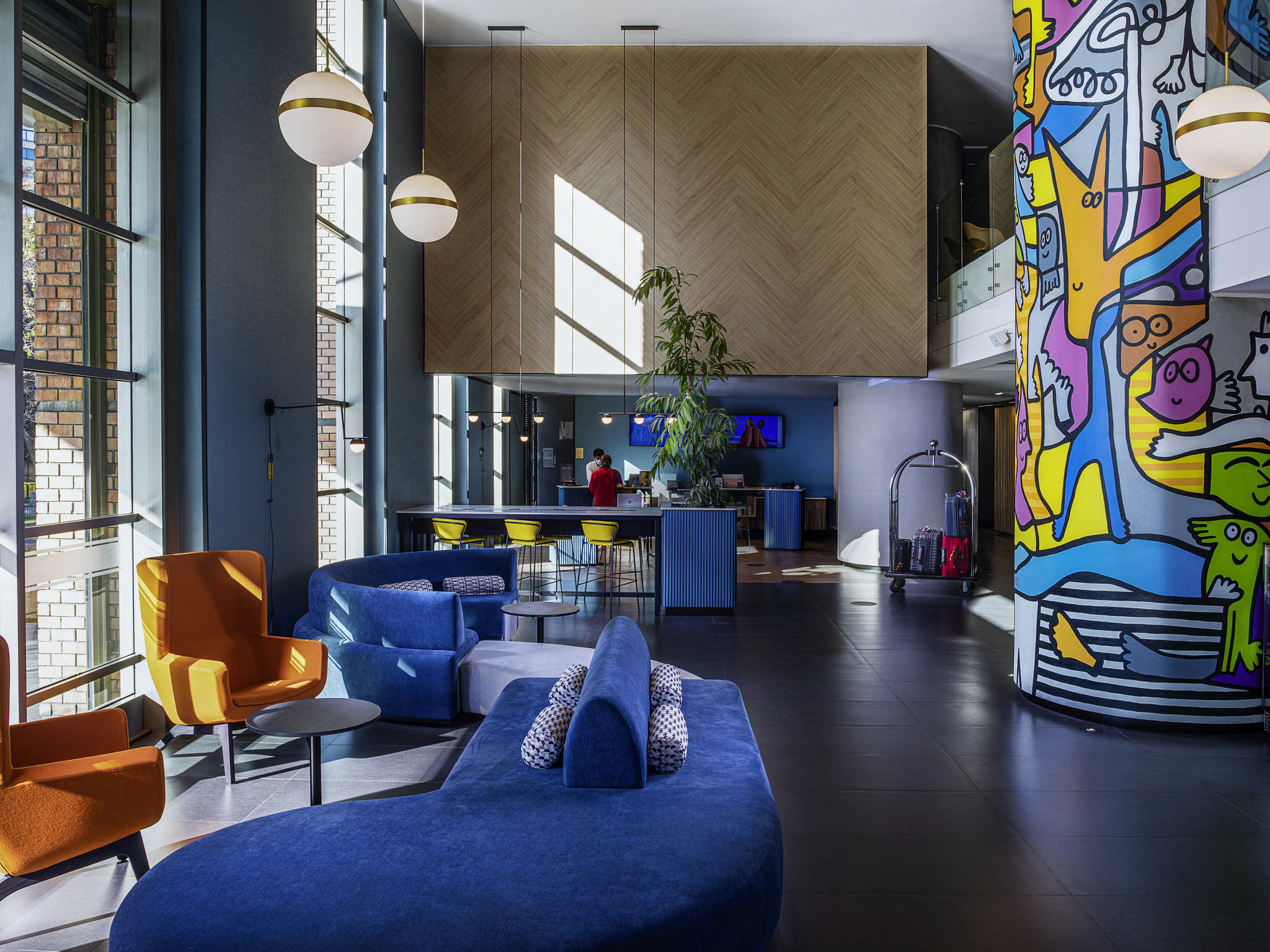 lobby del hotel Novotel en Chile. Sillones, sillas y una columna pintada con caricarutas.